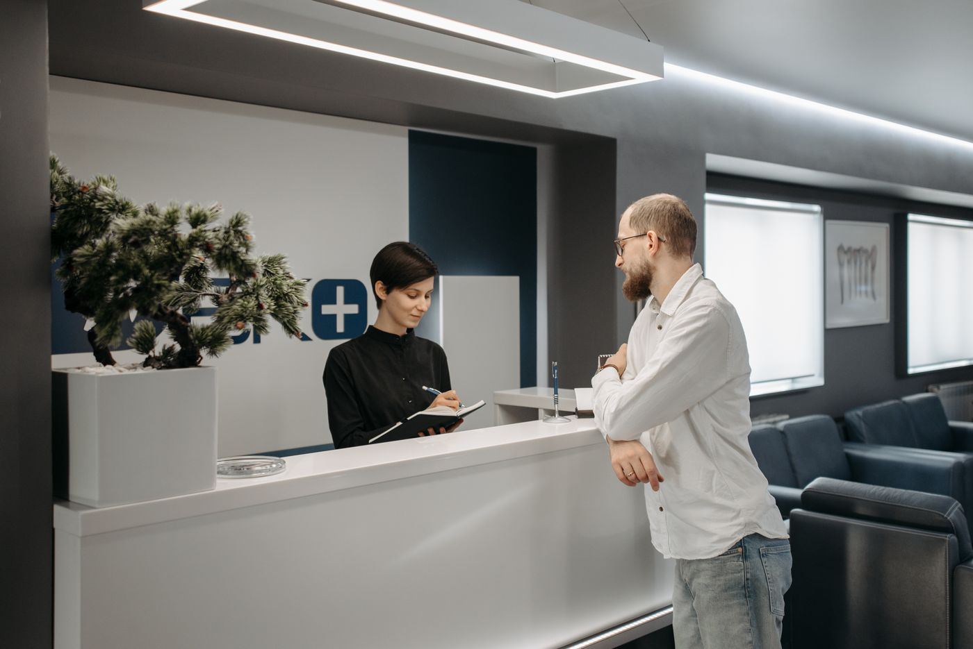 Recepção de escritório com atendente e cliente