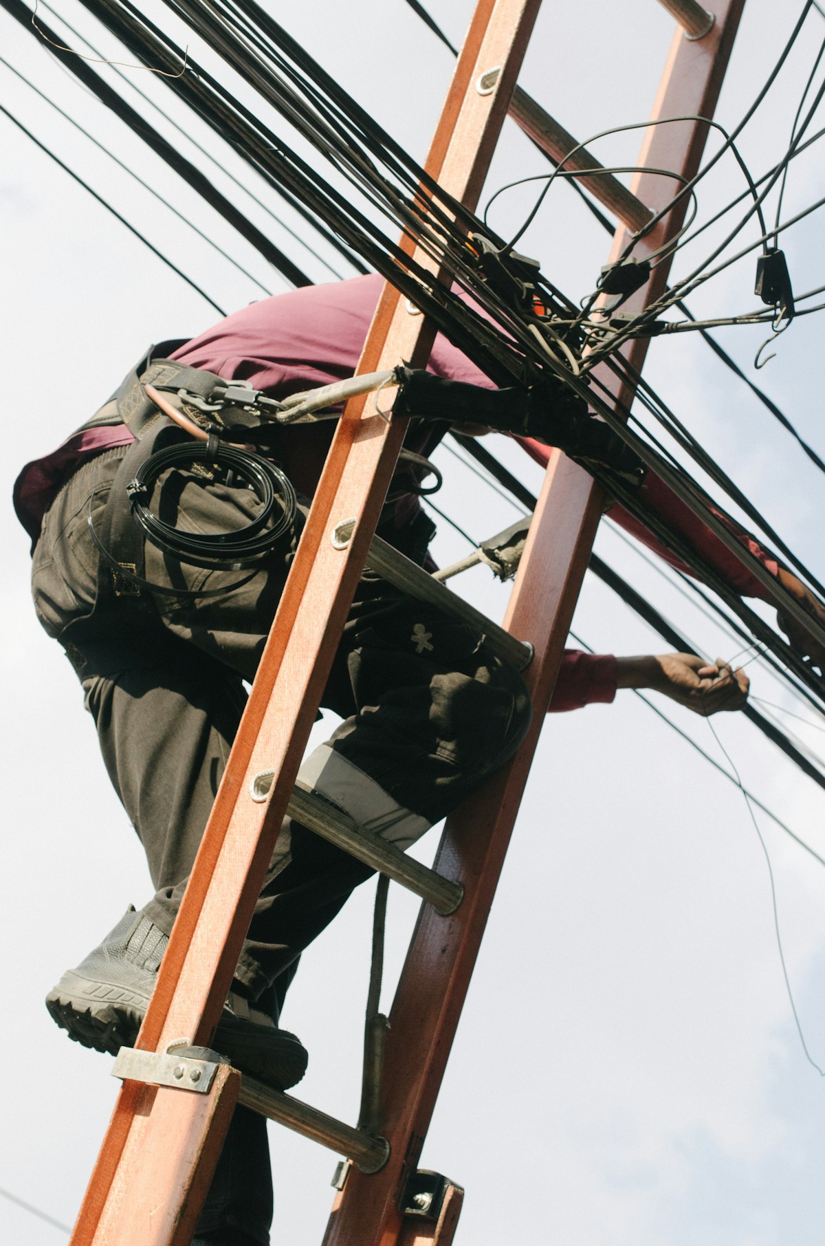 Técnico em escada instalando cabeamento